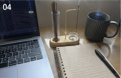 The Kodo Burner on a work desk beside a laptop and notebook