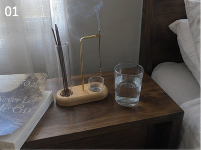 The Kodo Burner on a nightstand beside a book and water glass