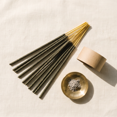 Hand-rolled incense sticks fanned beside a brass ash dish