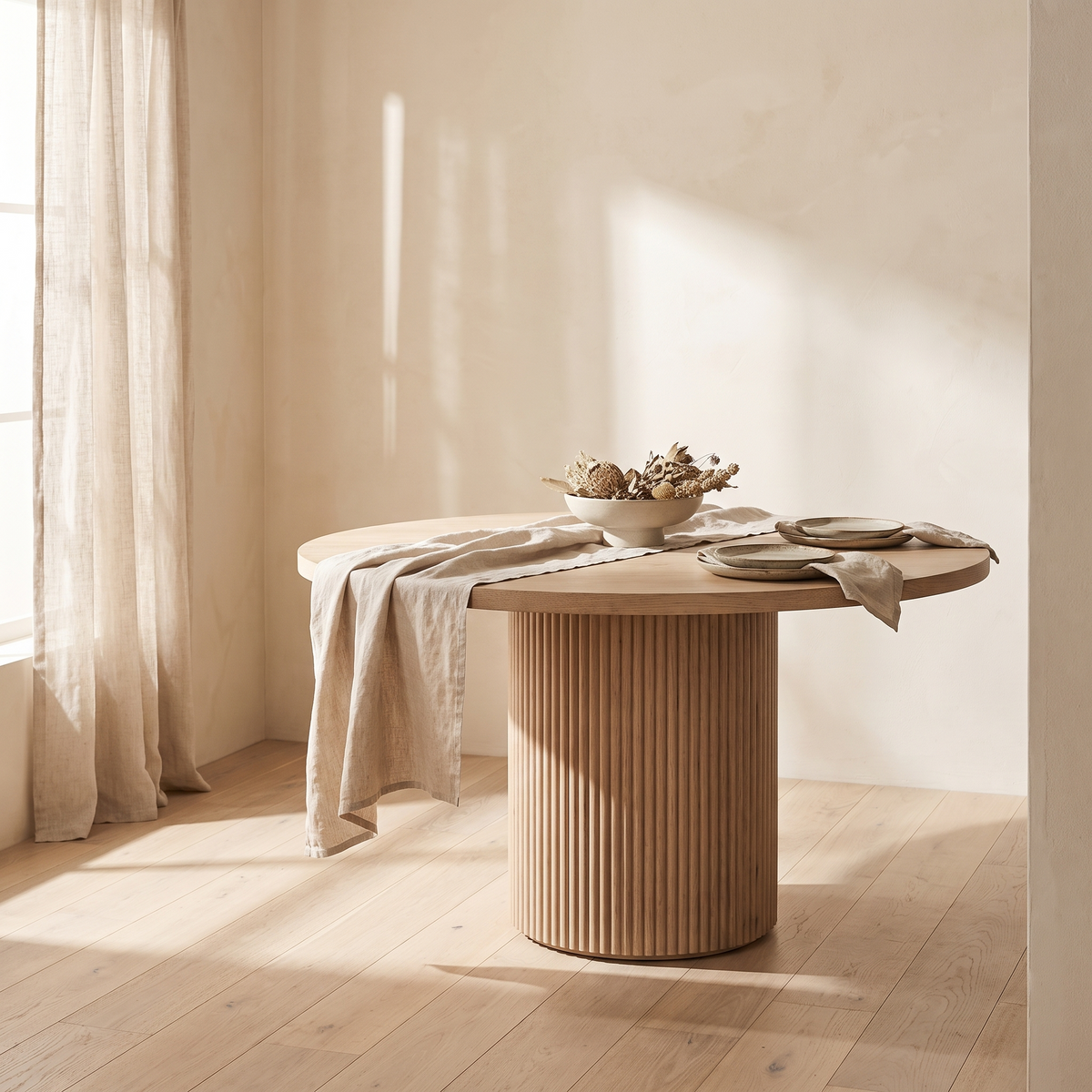 Fluted pedestal dining table styled in a bright dining room