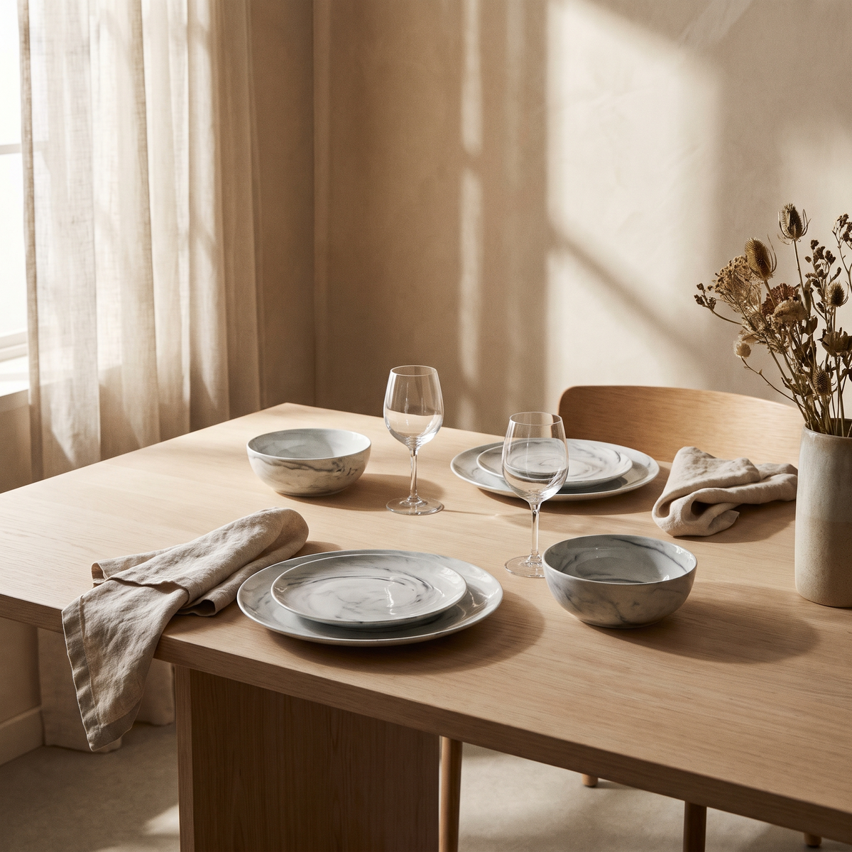 Marbled dinnerware laid on a pale oak table