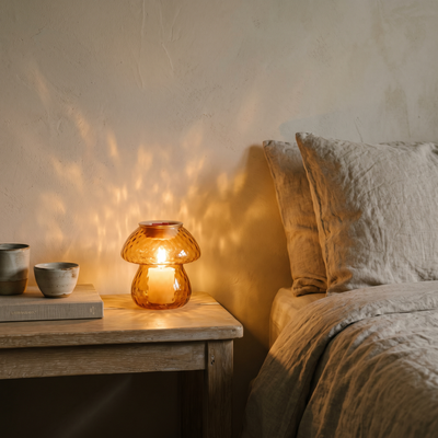 Mushroom warmer glowing on a bedside table at dusk