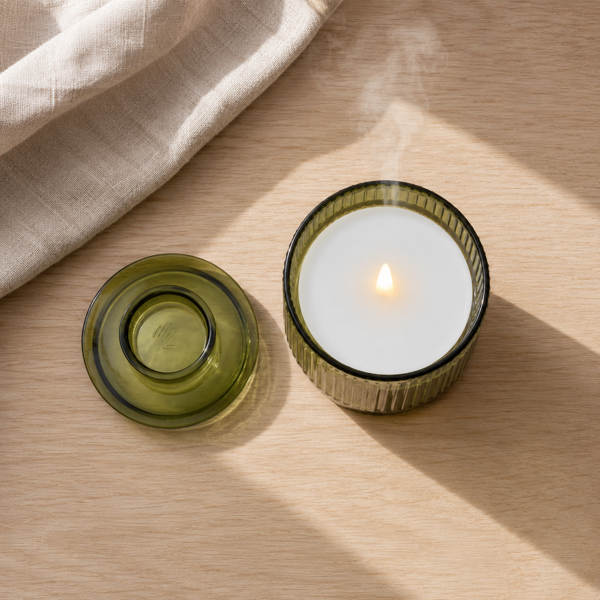 Top-down: the lid and the lit candle on oak