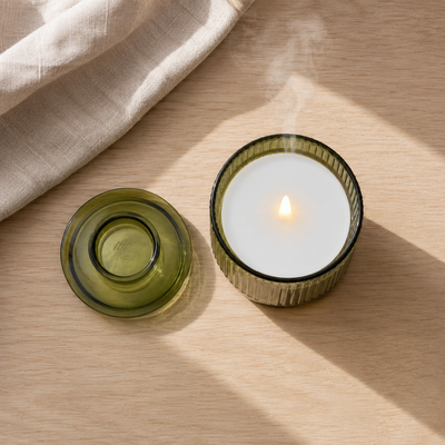 Top-down: the lid and the lit candle on oak